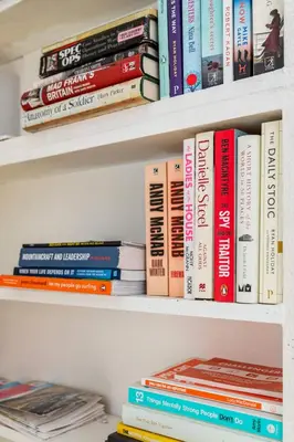 a bunch of books sitting on a shelf at Edinburgh, DeanVillage Cosy Hideaway Apartment in Edinburgh