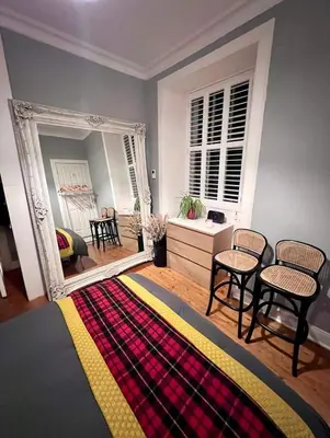 a living room with a mirror and a rug at Edinburgh, DeanVillage Cosy Hideaway Apartment in Edinburgh