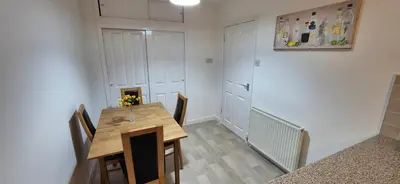 a dining room with a wooden table and chairs at Stirling apartment - free parking in Stirling