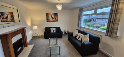 a living room with a couch and a fireplace at Stirling apartment - free parking in Stirling