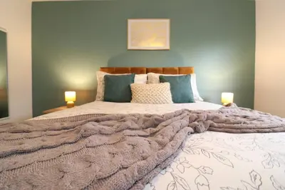a bedroom with a large bed with a blanket at Modern 3BR Home with Parking in East Kilbride