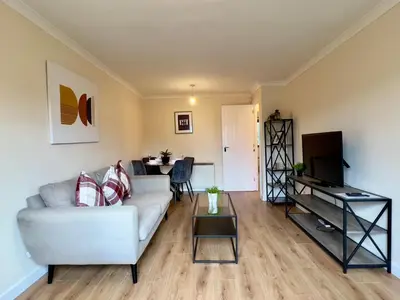 a living room with a white couch and a table at Garden-View 2BR Apartment - Free Parking & WiFi in Glasgow