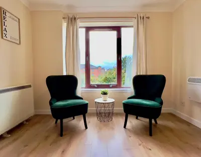two chairs and a table in a room with a window at Garden-View 2BR Apartment - Free Parking & WiFi in Glasgow