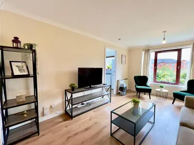 a living room with a couch and a tv at Garden-View 2BR Apartment - Free Parking & WiFi in Glasgow