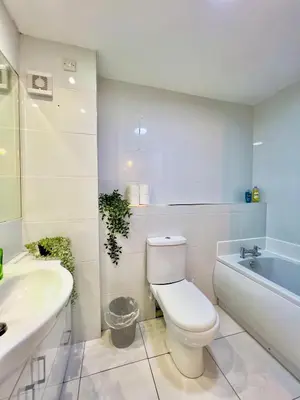 a bathroom with a toilet and a sink and a tub at Garden-View 2BR Apartment - Free Parking & WiFi in Glasgow