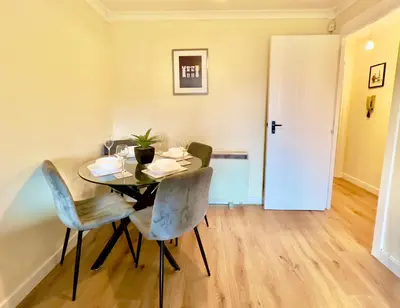 a dining room with a table and chairs and a door at Garden-View 2BR Apartment - Free Parking & WiFi in Glasgow