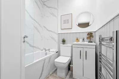 a white bathroom with a toilet and a sink at Welcoming Home In Renfrew, Near Glasgow Airport - Bonnie Lodgings in Renfrew