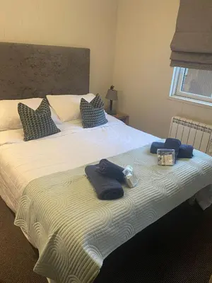 a bedroom with a large bed with towels on it at Ardeonaig Rock in Morenish