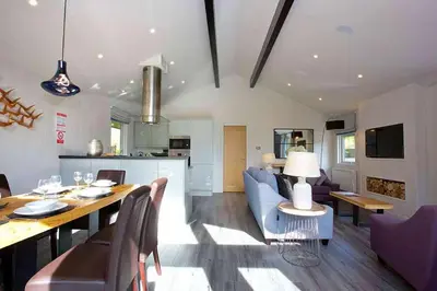 a dining room and living room with a table and chairs at Ardeonaig Rock in Morenish