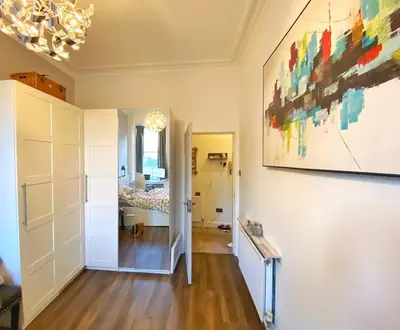 a room with a bed and a painting on the wall at Two-bedroom city retreat close to top sites in Edinburgh