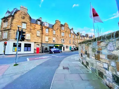 a street with a flag on a wall and a building at Two-bedroom city retreat close to top sites in Edinburgh