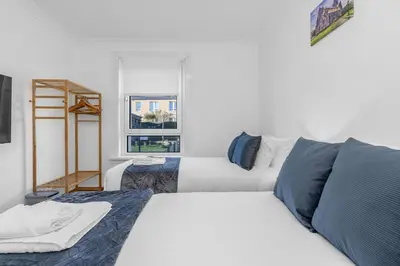 a white bedroom with a bed and a ladder at Executive 3 Bedroom - Corporate And Contractor Stays in Glasgow