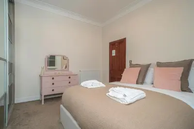 a bedroom with a bed and a tv on a dresser at Georgian Elegance with Patio Garden West End - Pass the Keys in Edinburgh