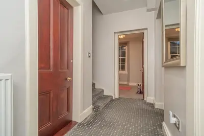 a hallway with a wooden door and a staircase at Georgian Elegance with Patio Garden West End - Pass the Keys in Edinburgh