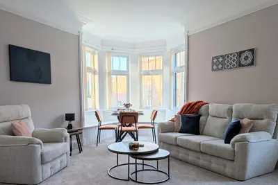 a living room with two couches and a table at Longrow Apartment in Campbeltown