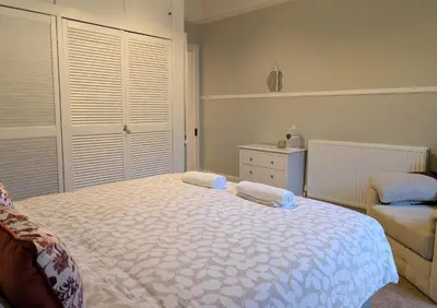 a bedroom with a bed with two towels on it at Longrow Apartment in Campbeltown