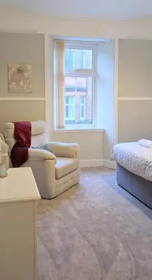 a living room with a couch and a bed at Longrow Apartment in Campbeltown
