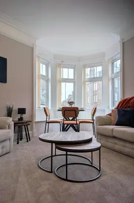 a living room with a table and chairs and a couch at Longrow Apartment in Campbeltown