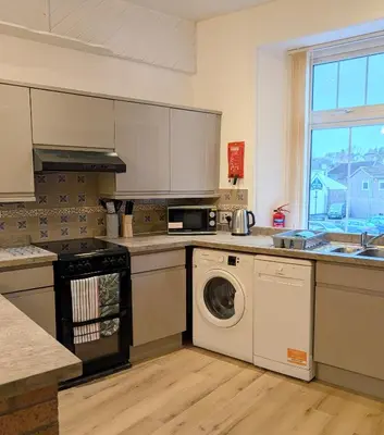 a kitchen with a washer and dryer in it at Longrow Apartment in Campbeltown