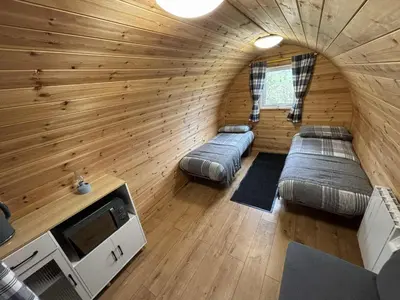 a room with two beds in a wooden room at Pentland View Campsite in Haywood
