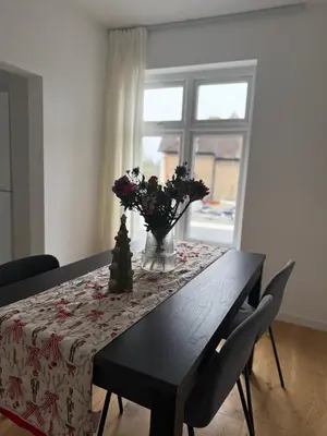 a dining room table with a vase of flowers on it at Private Rooms Near Acton Main Line Direct Elizabeth Line to Heathrow in Moffat