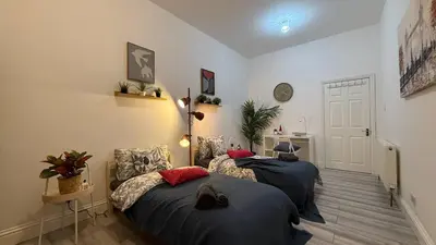 a bedroom with two beds and a door at Glasgow centre New property in Glasgow