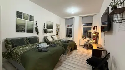 a bedroom with two beds and a living room with windows at Glasgow centre New property in Glasgow