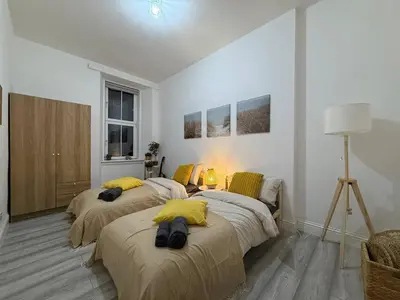 a bedroom with two beds with yellow pillows on them at Glasgow centre New property in Glasgow