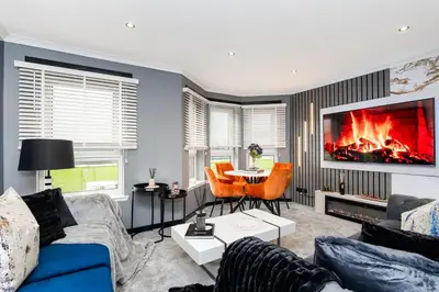 a living room with a couch and a fireplace at The Apartment in Paisley