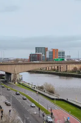 a bridge over a river with cars on a highway at The Lancefield Luxe in Glasgow