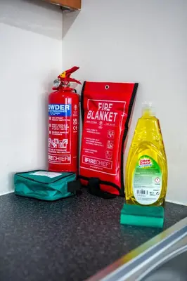 a counter with a fire cleaner and a bottle of water at The Lancefield Luxe in Glasgow