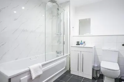 a white bathroom with a shower and a toilet at The Lancefield Luxe in Glasgow