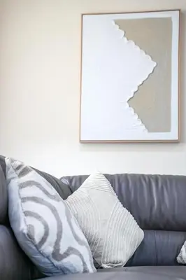 a couch with a pillow on it in a living room at The Lancefield Luxe in Glasgow