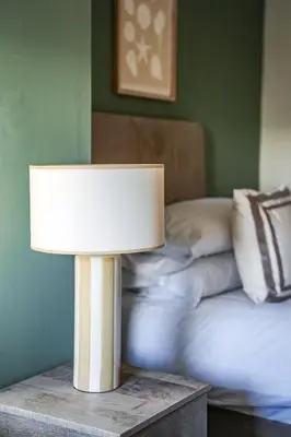 a lamp on a table next to a bed at Cruachan House in Falkirk