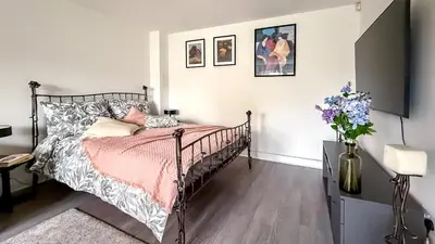 a bedroom with a bed and a vase of flowers at New Modern Detached House with 5bdr Glasgow in Renfrew