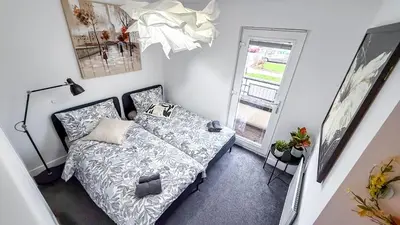 a small bedroom with a bed and a window at New Modern Detached House with 5bdr Glasgow in Renfrew