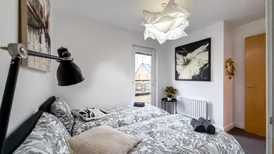 a bedroom with a bed and a lamp at New Modern Detached House with 5bdr Glasgow in Renfrew