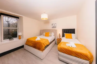 two beds in a room with a window at Charming and Spacious City Getaway 3 in Edinburgh