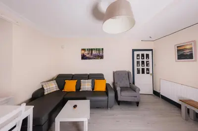 a living room with a couch and a chair at Charming and Spacious City Getaway 3 in Edinburgh