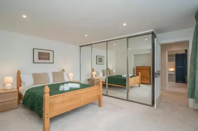 a bedroom with two beds and a glass wall at Spacious 5-Bed Home with Garden Parking - Pass the Keys in Edinburgh
