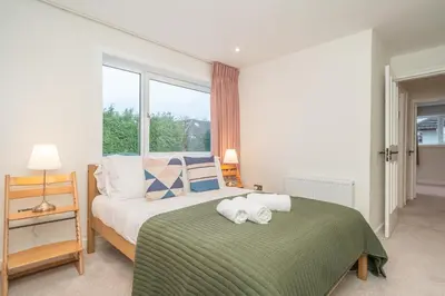 a bedroom with a bed with a green blanket at Spacious 5-Bed Home with Garden Parking - Pass the Keys in Edinburgh