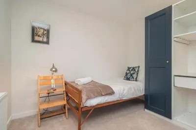 a small bedroom with a bed and a desk at Spacious 5-Bed Home with Garden Parking - Pass the Keys in Edinburgh