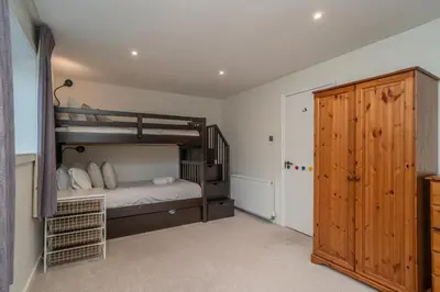 a bedroom with a bunk bed and a wooden door at Spacious 5-Bed Home with Garden Parking - Pass the Keys in Edinburgh
