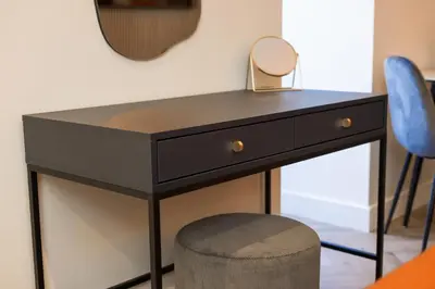 a black dressing table with a mirror and a stool at Old Kirk Apartment in Oban