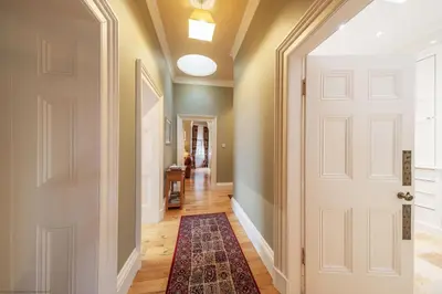 a hallway with a white door and a rug at Cleish Apartment in Edinburgh