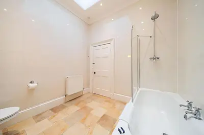 a bathroom with a shower and a tub and a sink at Cleish Apartment in Edinburgh