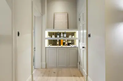 a hallway with a shelf with bottles of wine at Goldsmiths Georgian Residence in Edinburgh