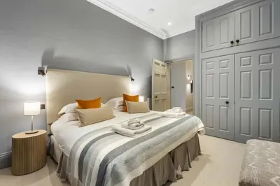 a large bedroom with a large bed with a white bedspread at Goldsmiths Georgian Residence in Edinburgh