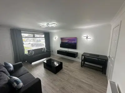 a living room with a couch and a piano at Family - Garden - Parking - WiFi - Sleeps 5 in Tullibody