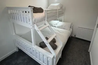 a white bunk bed in a room with a bed at Family - Garden - Parking - WiFi - Sleeps 5 in Tullibody